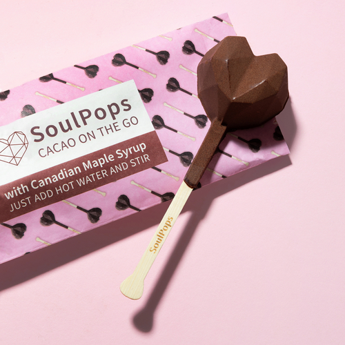 soulpops cacao on the go wrapper with raw soulpop on stirrer sitting on top